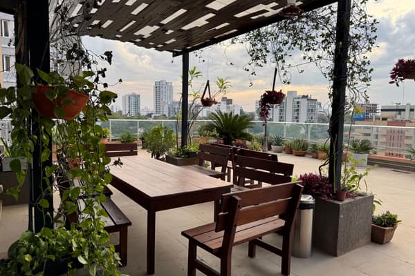 Terraza de la oficina de Asunción con mesas de madera y la ciudad al fondo